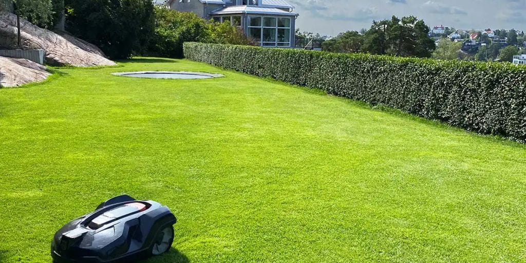 A robotic lawn mower on a freshly cut green lawn.