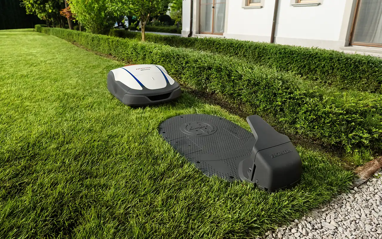 Honda Miimo robotgräsklippare på väg in för laddning i laddstationen
